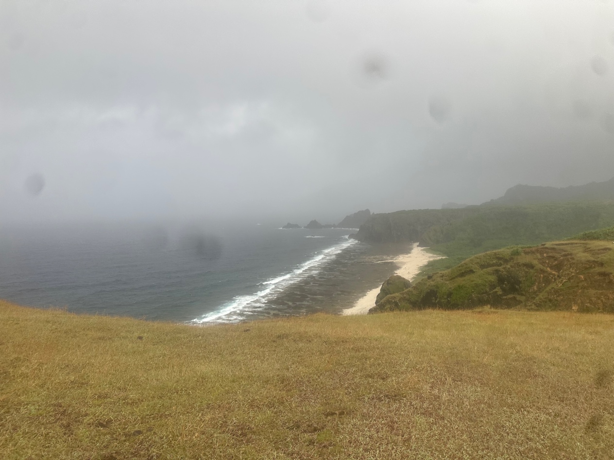 Atop a hill, dark clouds can be seen threatening Green Island.